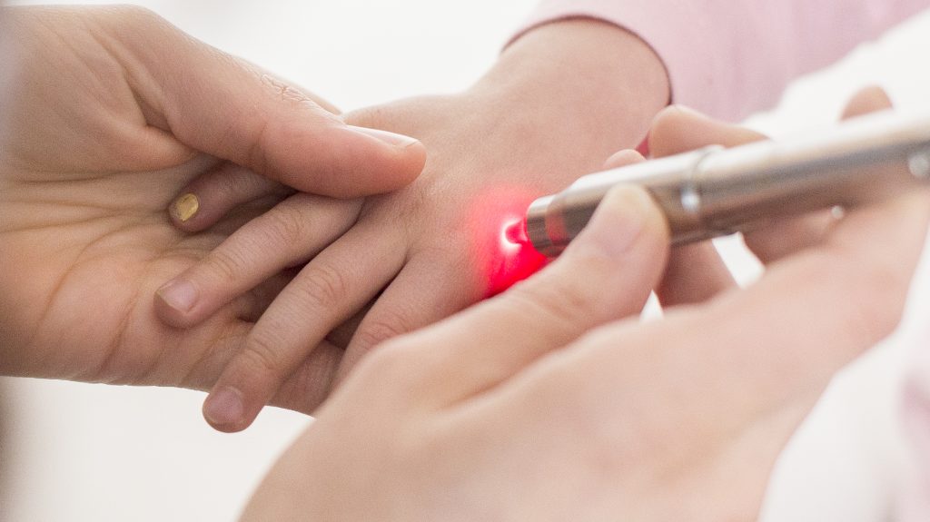 Laser leuchtet auf die Hand von einem Kind