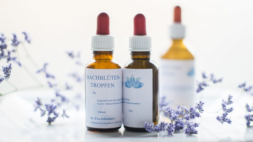 Drei Gläschen mit Bachblüten-Tropfen und Lavendel Blüten sind am Tisch